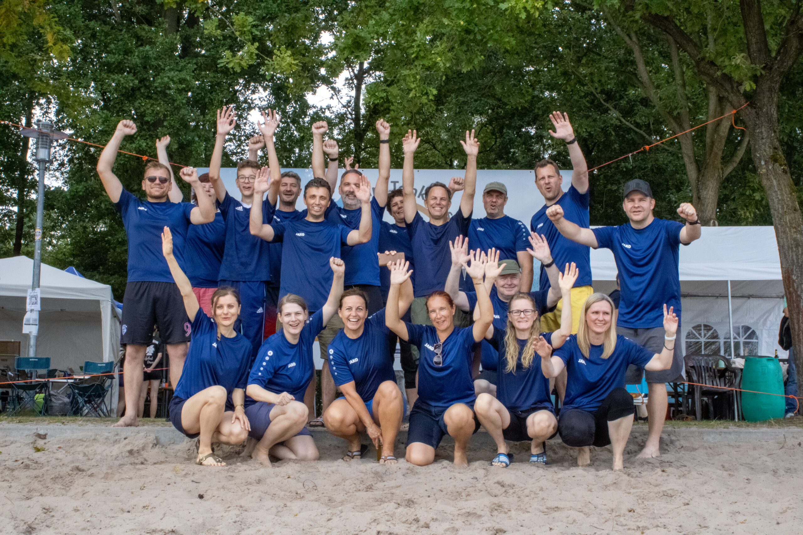 Eine Gruppe an blau gekleideten Personen jubelt